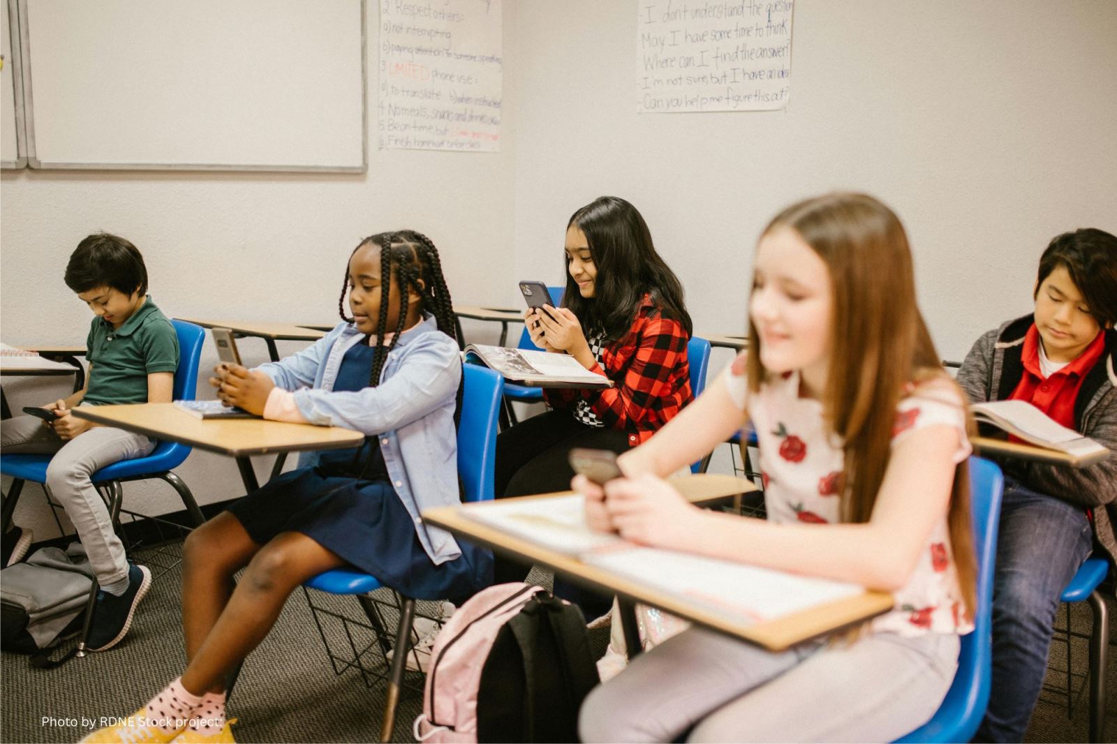 Students sitting at their desks using their cell phones